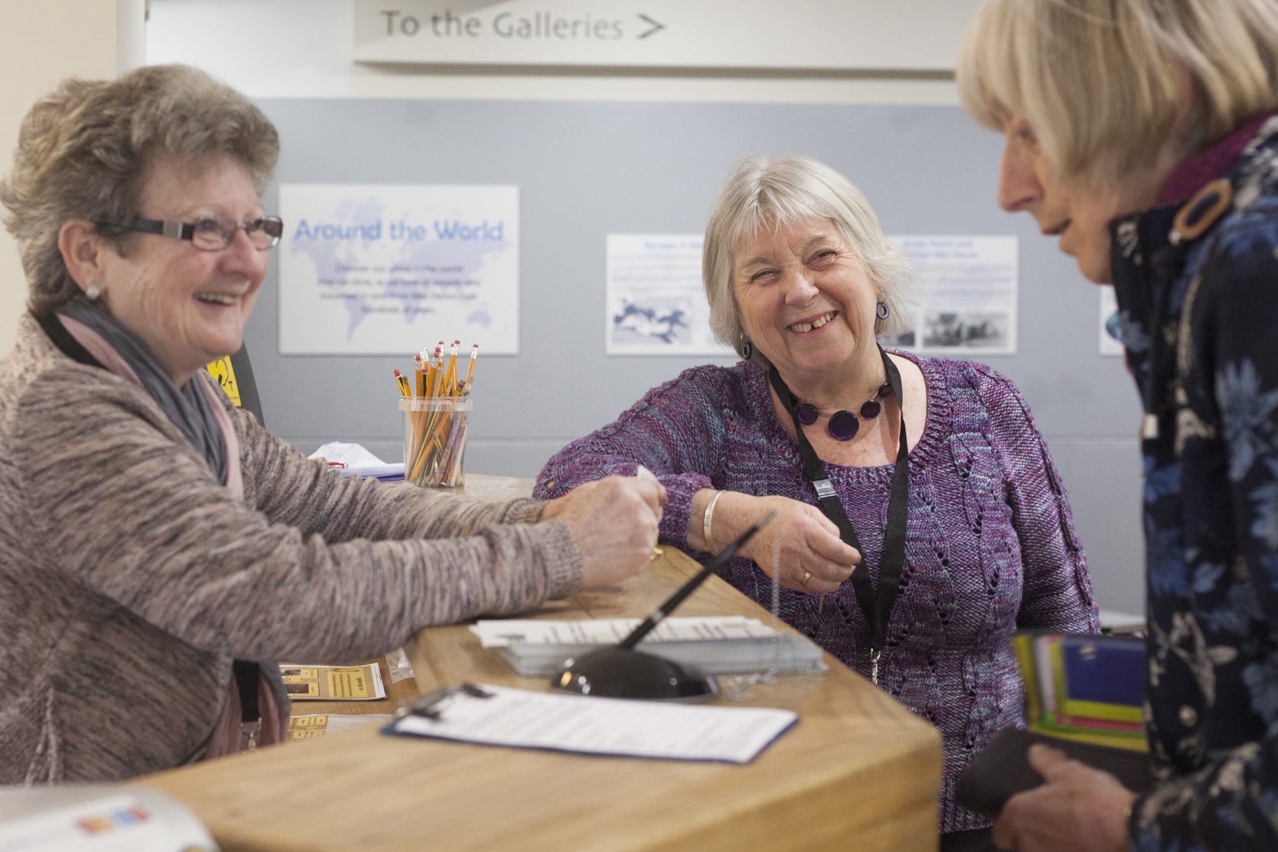 Three women standing at the museum reception