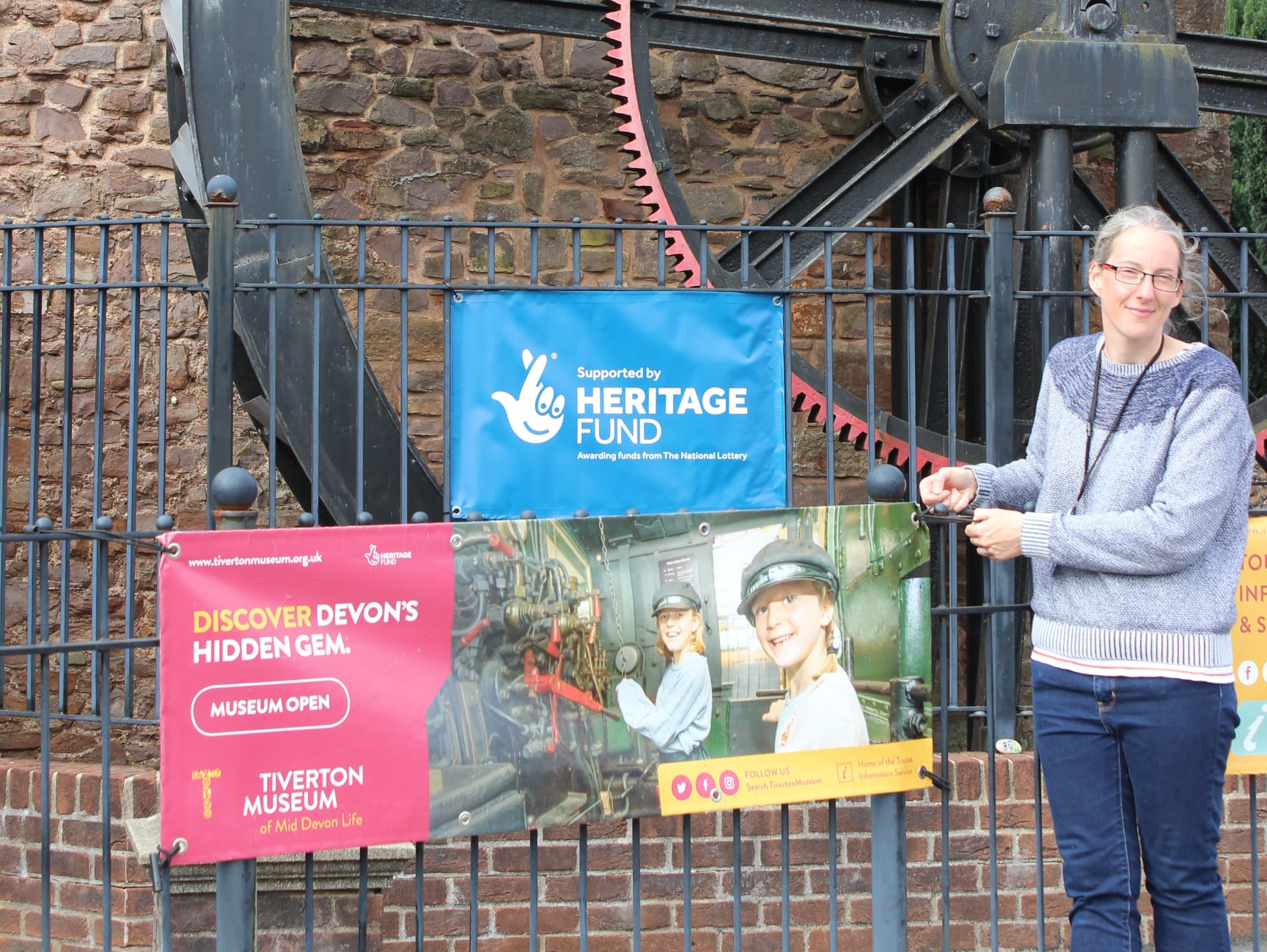 Museum Director putting open banner outside museum for the first time in nearly 6 months