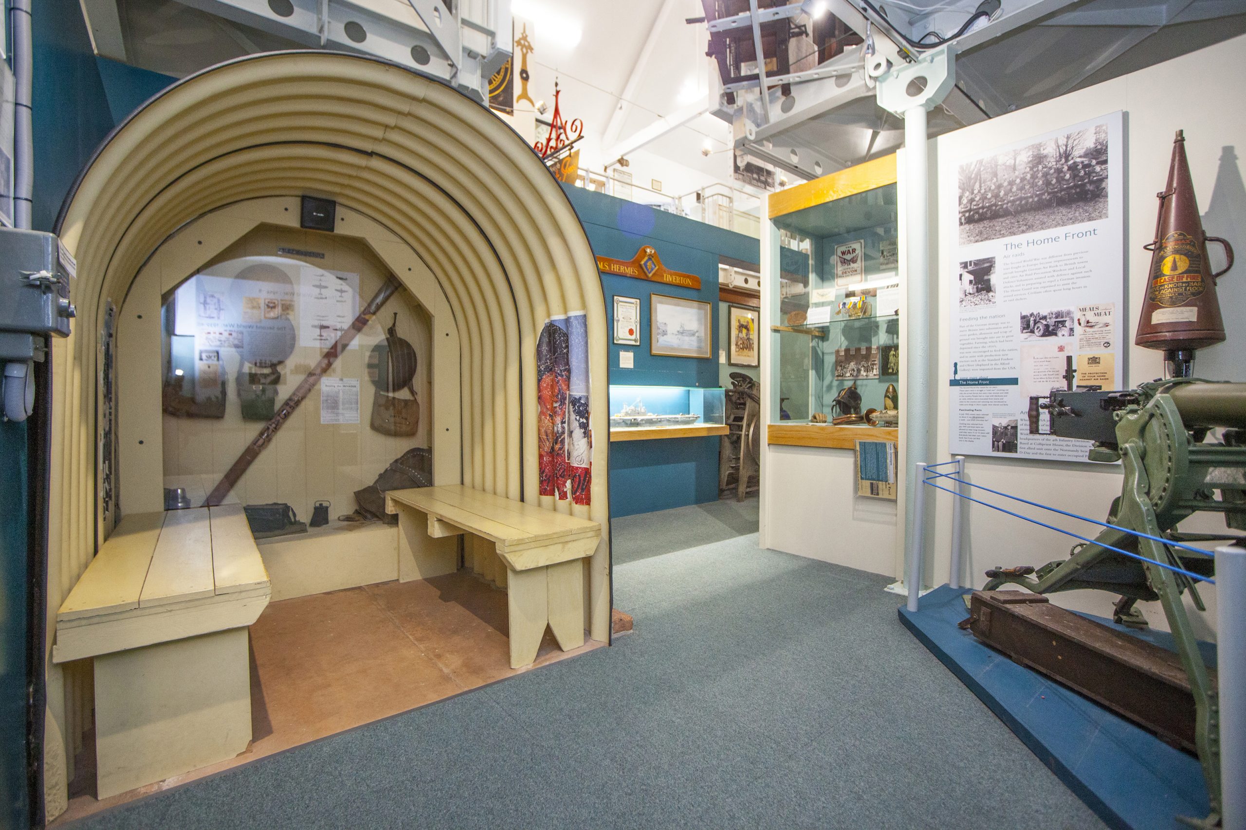 An Anderson airraid shelter on display in a museum gallery.