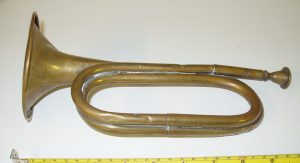 A brass bugle which is slightly dented and misshapen through use. 