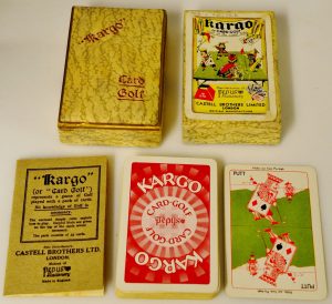 A card game called 'Kargo' or Card Golf. The box is displayed with the instructions and the playing cards, with one turned up to show the card's face. The card on display is 'Putt' and shows a playing card style King making a putt on a golfing green. 