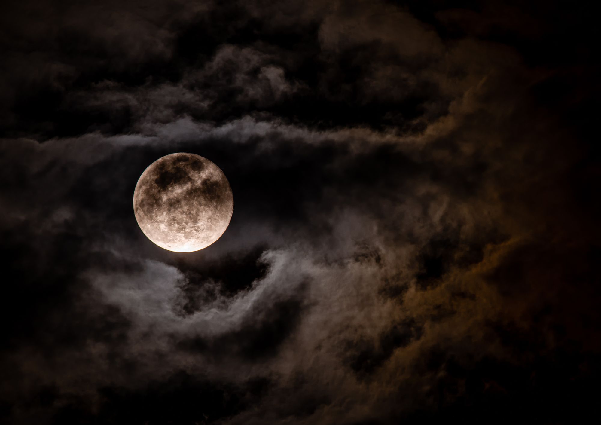 A full moon partially covered by cloud