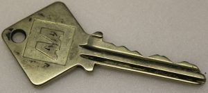 A silver key with AA engraved in capital letters