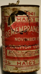 A battered looking old tin with a ripped paper covering. You can make out some of the writing which shows it is a collection tin for 'Earl Haig's Appeal' from 1941