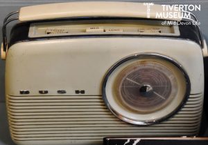 An old style radio with white plastic casing