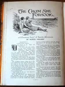 A story from the 'Golden Annual for Girls 1927'. the story is 'The Chum She Forsook - A Charming Story of Seaside Adventure by Muriel Holden'. There is an illustration above the story of two girls sitting in loose-fitting 1920s style dresses on a beach with a pier behind them. One of the girls is pointing out to sea.